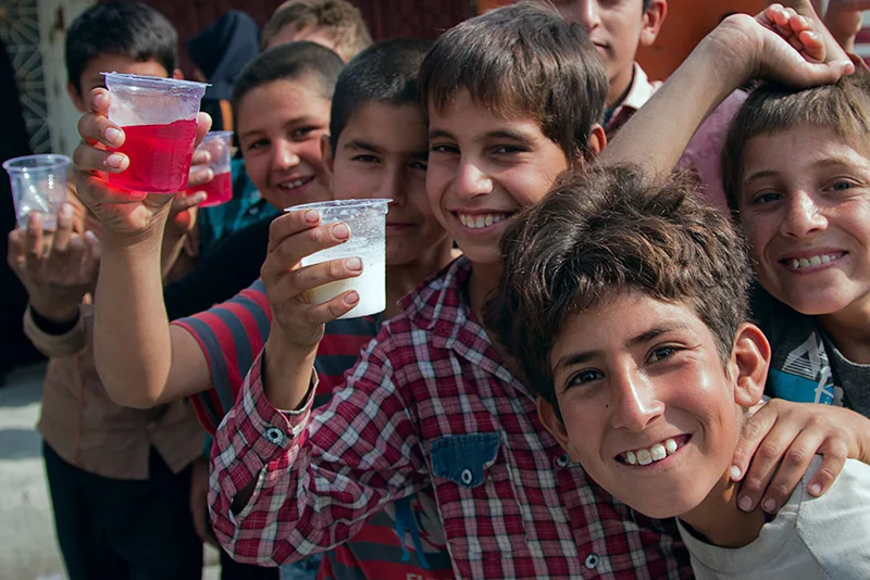 A group of smiling children holding up cups